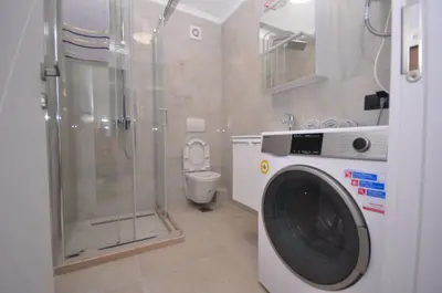 a washing machine in a bathroom with a toilet at Studio Dobra Voda 14 in Bar