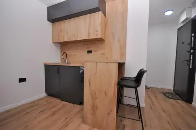 a kitchen with a counter and a chair in a room at Studio Dobra Voda 14 in Bar