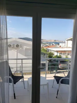 a balcony with a view of the city through the sliding glass doors at Уютная 1-комнатная квартира с видом на море! in Bar