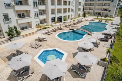 an overhead view of a pool with chairs and umbrellas at Apartments Nesi in Ulcinj