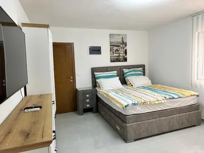 a bedroom with a bed and a television in it at Апартаменты - студия in Bar
