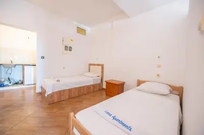 two beds in a room with white walls at Lana Apartments in Ulcinj