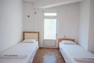 two beds in a room with a window at Lana Apartments in Ulcinj