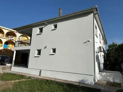 a large white building with a large door at Apartmani Aki 6 in Sutomore