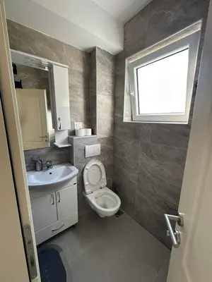 a bathroom with a toilet and a sink and a window at Apartmani Aki 4 in Bar