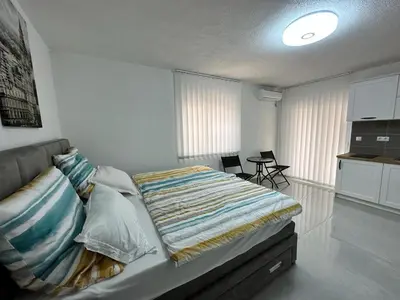 a bedroom with a bed and a kitchen in it at Студия, 800 м до моря in Bar