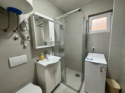 a bathroom with a shower and a toilet and a sink at Студия, 800 м до моря in Bar