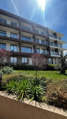 an apartment building with a garden in front of it at Casa Montenegro Lux Apartment 1 Bedroom 1 livingroom Sea & Pool View in Tivat