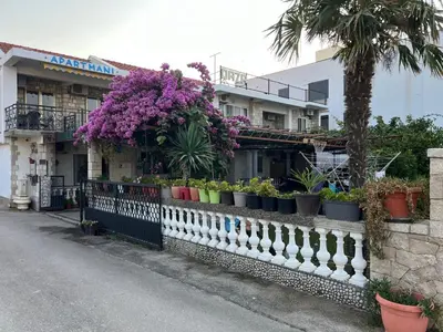 a fence with potted plants on it next to a building at Apartman Oaza 1 in Ulcinj