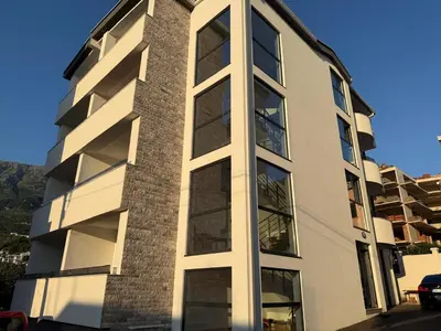 a tall white building with large windows at Apartment Buena vista in Dobra Voda