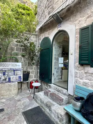 a stone building with green doors and a table at Balcony with Old Town view in Kotor