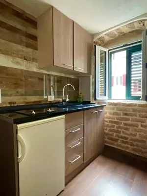 a kitchen with wooden cabinets and a sink and a window at sar 4 in Kotor