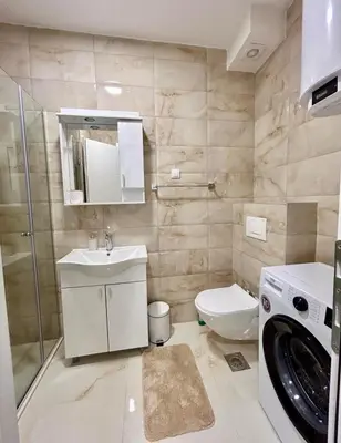 a bathroom with a toilet sink and a washing machine at Apartman Živaljević 3 Tivat in Tivat