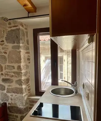 a kitchen with a sink and a stone wall at Square view in Kotor