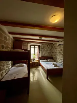 a room with three beds in it with a window at bella 11 in Kotor