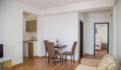a living room and kitchen with a table and chairs at Lotos - stan 318 in Dobra Voda