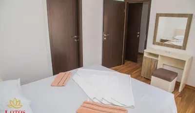 a bedroom with a white bed with a mirror at Lotos - stan 318 in Dobra Voda