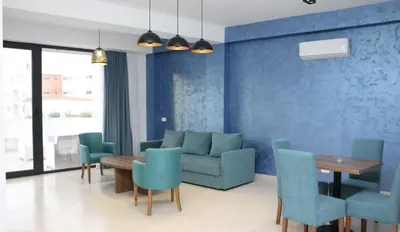 a living room with a couch and a table and chairs at Lotos - stan 212 in Dobra Voda