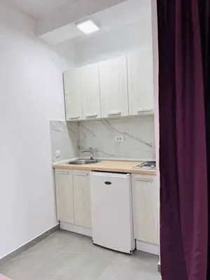 a small kitchen with white cabinets and a white refrigerator at SoFi in Ulcinj