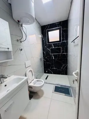 a white bathroom with a toilet and a sink at SoFi in Ulcinj