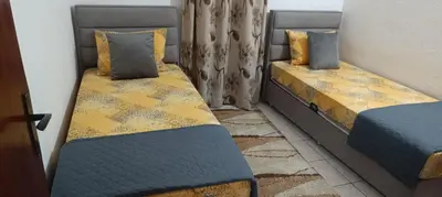 two twin beds in a room with a window at Apartman V,P in Sutomore