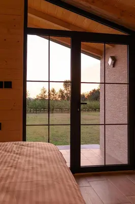 a bedroom with a large glass door with a view of a field at Jelena in Balabani