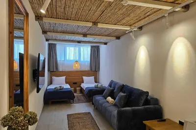 a living room with a blue couch and a bed at High-End Villa with Private Beach Access in Brca