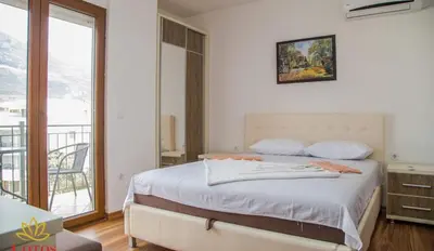 a bedroom with a large bed and a balcony at Lotos - stan 211 L2 in Dobra Voda