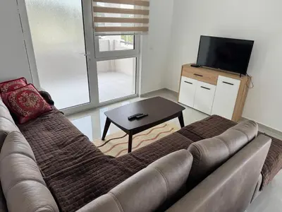 a living room with a couch and a television at Apartmani in Sutomore