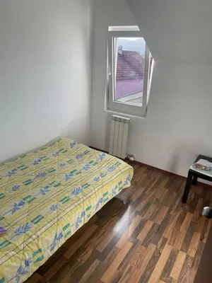 a small bedroom with a bed and a window at Duplex apartment in Podgorica in Podgorica