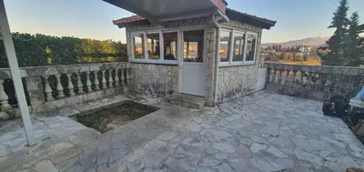 a small house with a fence and a stone patio at Anika in Podgorica