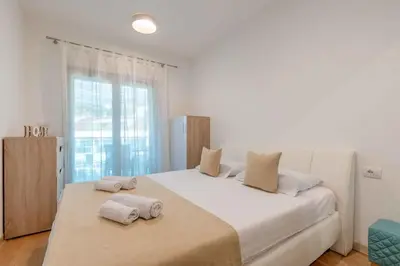 a bedroom with a large white bed with towels on it at Apartment Pržno See View in Pržno