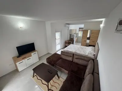a living room with a couch and a bed at Sutomore Apartman in Sutomore