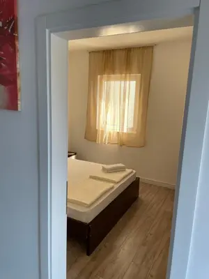 a small bedroom with a bed and a window at Apartment Lupo in Budva