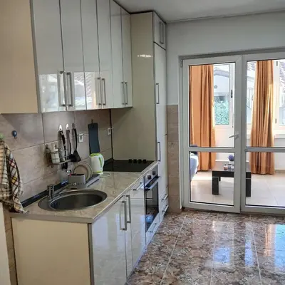 a kitchen with a sink and a sliding glass door at Veli Vinogradi in Budva