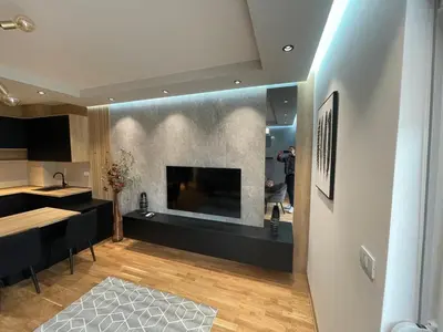 a kitchen and living room with a large fireplace at Montenegro Black Suite in Podgorica