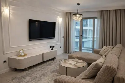 a living room with a couch and a tv on a wall at New sea view luxury apartment in center in Budva
