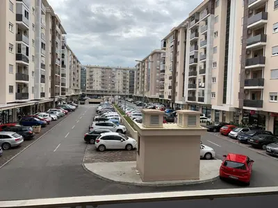 a parking lot full of parked cars in a city at Apartments New City in Podgorica