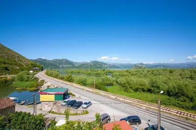 a parking lot with cars parked next to a road at Skadar Lake Apartment-Nikola in Podgorica