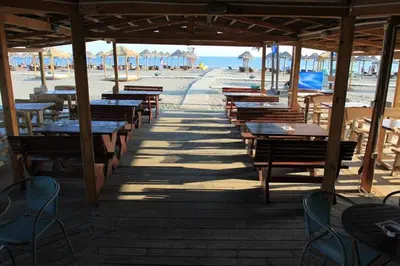 a row of tables and benches on the beach at Villa Elkom, Appartment 7 in Donji Štoj