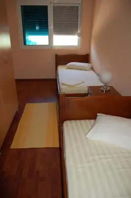a small room with three beds and a window at Villa Elkom, App 6 in Ulcinj