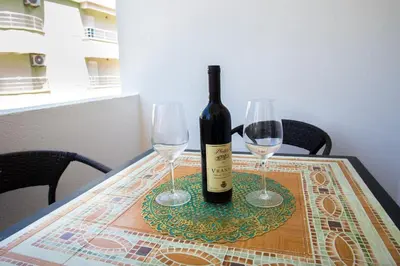 a bottle of wine and two wine glasses on a table at Villa Elkom App 2 in Ulcinj