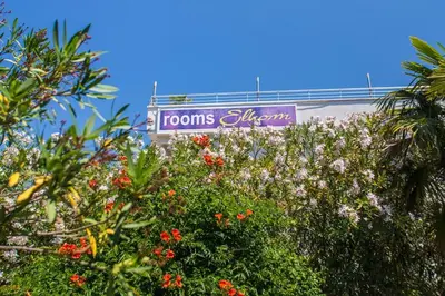 a sign for the rooms atlantis sign behind trees at Villa Elkom, App.9 in Ulcinj