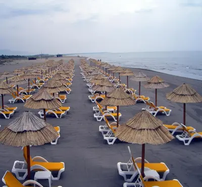 a row of chairs and umbrellas on a beach at Villa Elkom, App.4 in Ulcinj