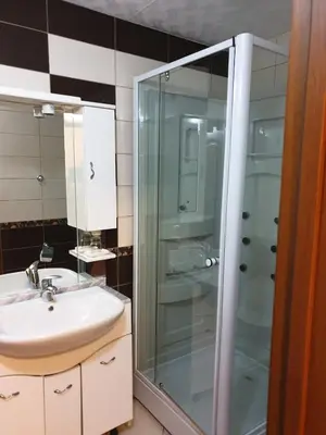 a bathroom with a glass shower and a sink at Villa Elkom, Ap 15 in Ulcinj