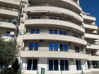 a tall white building with balconies on it at Holiday apartments Petrovac in Petrovac na Moru