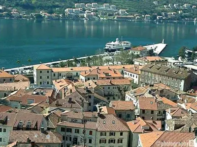 a city with buildings and a boat in the water at Cosy front line apt with sea access at your door step in Kotor