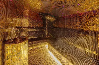 a large bathroom with gold tiled walls and a tub at Apartment in the luxury hotel near beach in Budva