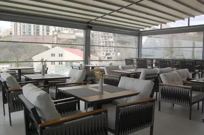 a restaurant with tables and chairs and large windows at Status-M Apartments 174 in Becici