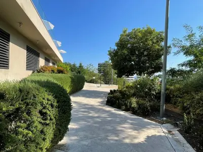 a walk way next to a building with bushes at Status-M Apartments 205 in Becici
